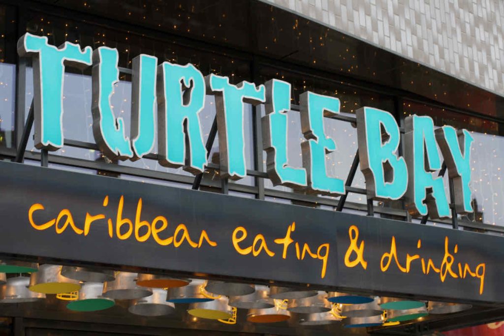 Exterior signage in turquoise letters for Turtle Bay Caribbean style restaurant, Walthamstow branch East London.