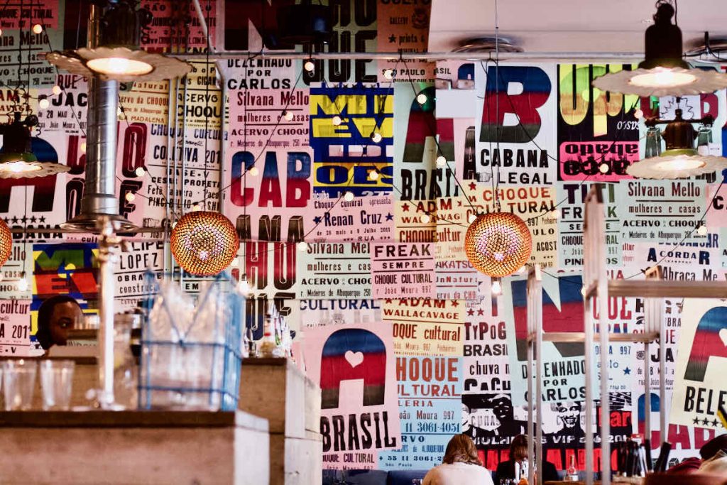 Interior showing printed Portuguese words on posters and various types of lighting as seen at Cabana Brazilian barbecue restaurant at Westfield Stratford branch East London.